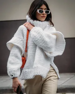 Close-up of oversized white chunky knit turtleneck sweater with fluffy long sleeves