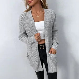 Close-up view showing the textured waffle knit pattern and side pocket of the grey cardigan