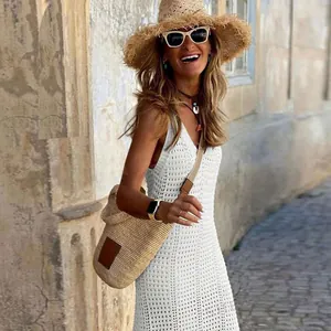 Lifestyle view of woman wearing a white crochet hollow-out knit beach cover-up dress
