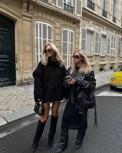 Oversized black chunky turtleneck sweater styled in a European street fashion setting
