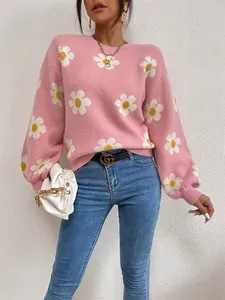 Détail d'un pull en maille rose oversize avec un motif floral de marguerites blanches