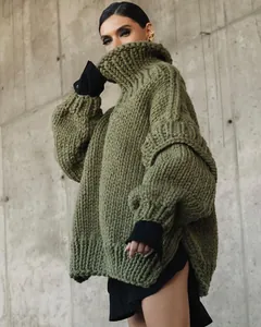 Detailed view of the olive green oversized chunky knit turtleneck sweater texture.