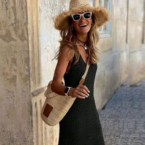 Stylish woman wearing a black crochet hollow-out beach cover-up dress with straw hat