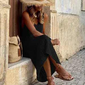 Lifestyle detail showing a chic black knitted hollow-out maxi beach cover-up dress