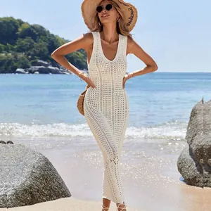 Boho chic white crochet beach cover-up dress modeled on a beautiful sunny coastline