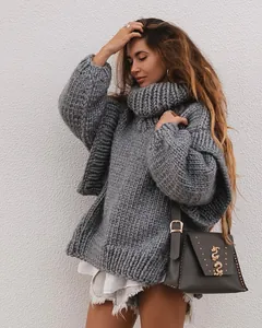 Close-up of a chunky grey turtleneck knit sweater showing thick texture and loose fit