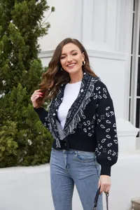 Mujer con cárdigan negro retro con estampado de cachemira y detalles de flecos al aire libre