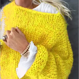 Detailansicht der weichen Textur eines leuchtend gelben Damen-Strickpullovers aus Mohair-Imitat