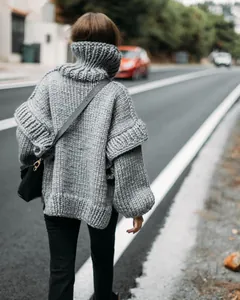Back view of a grey chunky-knit oversized turtleneck sweater with thick wool texture.