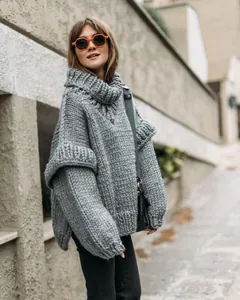 Detailed view of a grey chunky knit turtleneck sweater with fluffy sleeves
