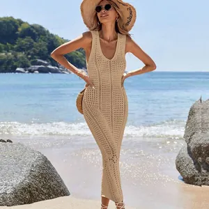Model wearing a beige knitted hollow-out beach cover-up dress on a sunny beach