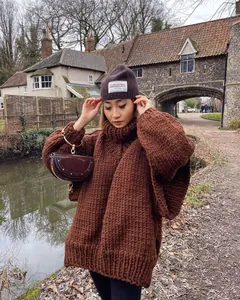 Close-up of oversized brown chunky knit turtleneck sweater with autumn styling