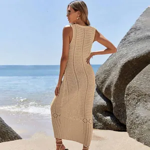 Elegant beige crochet knit maxi beach cover-up dress shown on a scenic sunny beach
