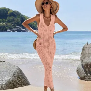 Beautiful pink crochet knit hollow-out maxi dress worn by a model on a sunny beach scene