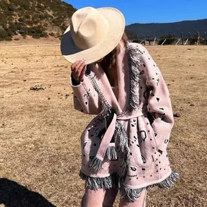 Detailansicht der rosa Retro-Strickjacke mit grauen Fransen und Quastensaum