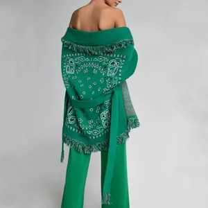 Gros plan du dos d'un cardigan rétro en tricot vert émeraude avec détails de franges