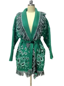 Détails d'un cardigan vert bohème avec motif paisley, franges décoratives et ceinture.