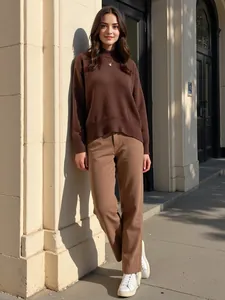 Mannequin portant un pull en maille marron à col rond avec un pantalon beige au soleil