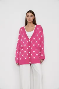 Stylish pink knitted cardigan featuring a white heart jacquard pattern on a model