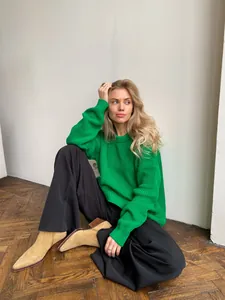 Chunky green oversized crew neck knit sweater for women styled in a minimalist room setting