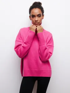 Vue rapprochée et détaillée d'un pull à col roulé rose vif surdimensionné pour femme