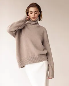 Detail of oversized taupe turtleneck knit sweater with drop shoulders and ribbed cuffs