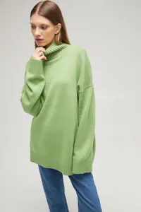 Oversized lime green turtleneck knit sweater for women styled with blue jeans