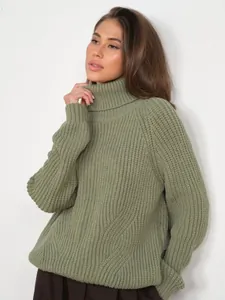 Detailed view of a woman wearing a loose olive green thick chunky knit turtleneck sweater