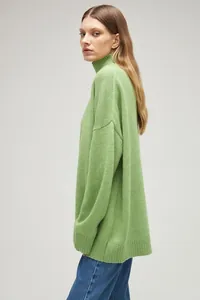 Detailed side profile of a woman wearing a cozy lime green oversized turtleneck sweater