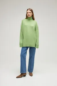 Close-up shot of a cozy oversized light green high-neck knit sweater for women fashion