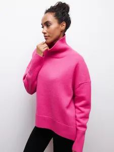 Vue latérale détaillée d'un pull à col roulé oversize rose vif pour femme sur un mannequin.