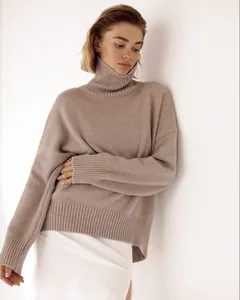 Professional detail shot of a loose turtleneck knitted sweater with soft texture.