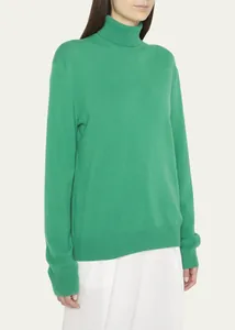 Detalle de la textura suave de un suéter de cuello alto de lana merino verde esmeralda para mujer