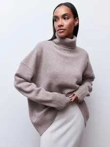 Detail of oversized taupe turtleneck knit sweater showing soft texture and cozy fit