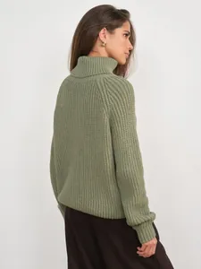 Detailed side view of a chunky sage green turtleneck knit sweater with ribbed texture
