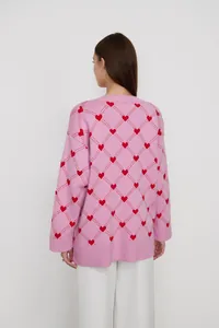 Detailed back view of a pink oversized knit cardigan featuring red heart diamond patterns
