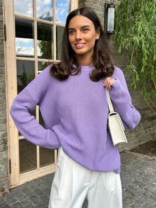 Detailed shot of a loose purple knit sweater worn by a female model in sunlight.