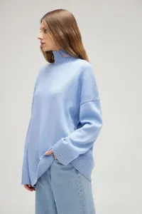Detail view of women's oversized light blue high-neck knitted sweater in a soft knit fabric