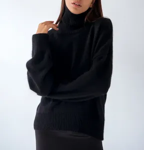 Close-up of black oversized turtleneck knit sweater showing ribbed hem and soft texture