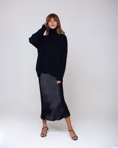 Elegant black oversized turtleneck knit sweater and matching satin midi skirt for winter.