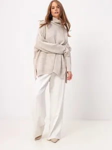 Stylish full-length look of a beige oversized turtleneck knit sweater and white pants