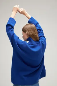 Detailed back view of a vibrant royal blue loose turtleneck knit sweater for women.