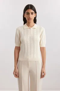 Front view detail showing the pointelle texture of a cream short-sleeved knit Polo shirt