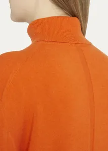 Primer plano de un jersey de cuello alto naranja para mujer en lana merina.