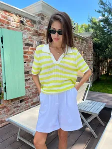Model wearing a casual yellow and white striped short-sleeve knit polo shirt outdoors