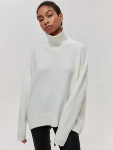 Détail d'un pull en maille blanc oversize à col roulé pour femme très confortable