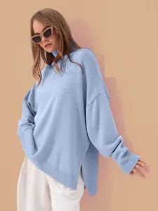Close-up of a women's light blue turtleneck knit sweater with side slits and loose fit