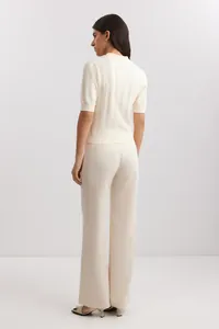 Back view of cream polo-collar short-sleeved knit sweater with pointelle texture