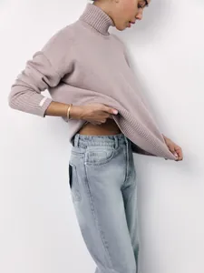 Detailed side view of loose-fit turtleneck sweater with soft knitted texture