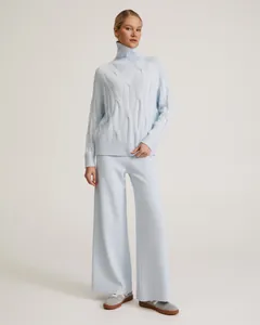 Detailed view of light blue cable-knit turtleneck sweater and matching wide-leg trousers